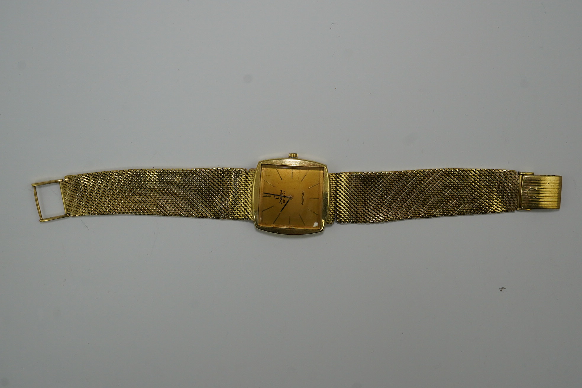 A gentleman's early 1960's 18ct gold Omega De Ville automatic dress wrist watch, on integral Omega 18ct gold mesh link bracelet